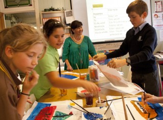 Children painting in class with Patricia